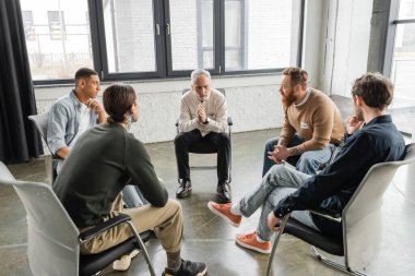 Multiethnic people with alcohol addiction sitting in circle in rehab center  clipart