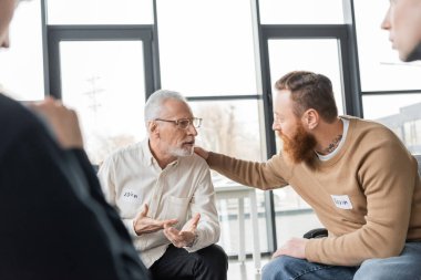 Middle aged man with alcohol addiction sharing problem with group in rehab center  clipart