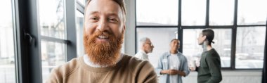 Bearded man looking at camera during alcoholics meeting in rehab center, banner  clipart