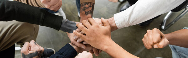Top view of interracial people with alcohol addiction holding hands in rehab center, banner 