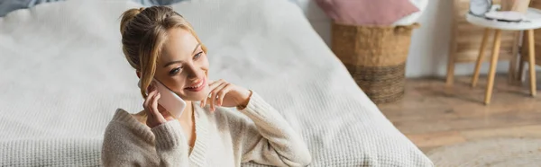 Onnellinen Nainen Neulottu Villapaita Puhuu Älypuhelimella Modernissa Makuuhuoneessa Banneri — kuvapankkivalokuva