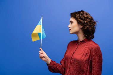 Mavi üzerinde Ukrayna bayrağı taşıyan kıvırcık dil öğretmeninin yan görünümü 