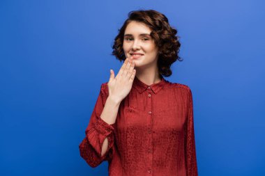 Gülümseyen öğretmen mavi üzerine izole edilmiş işaret diliyle teşekkür ediyor.