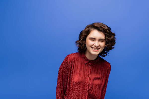 веселый учитель языка в красной блузке с животным отпечатком улыбки при закрытии глаза изолированы на синий 