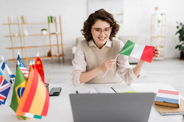 Jovem Professor Segurando Bandeira Itália Perto Laptop Livro Didático Língua — Fotografia de Stock