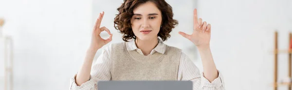 stock image curly sign language teacher showing alphabet letters with hands during online lesson, banner 