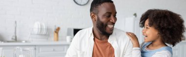 Mutlu Afro-Amerikan kızı Mutfakta neşeli babaya bakıyor 