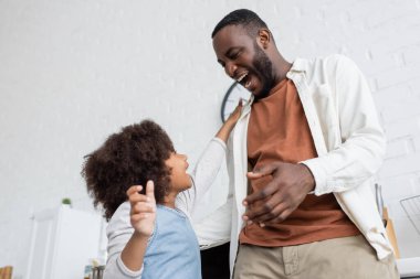 Kıvırcık Afrikalı Amerikalı çocuğun birbirine sarılmadan önce mutlu babaya el uzatması. 