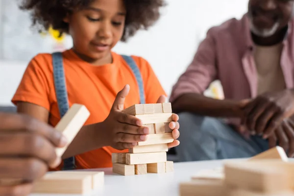 混淆不清的非洲裔美国孩子在父母身边玩木块游戏 — 图库照片