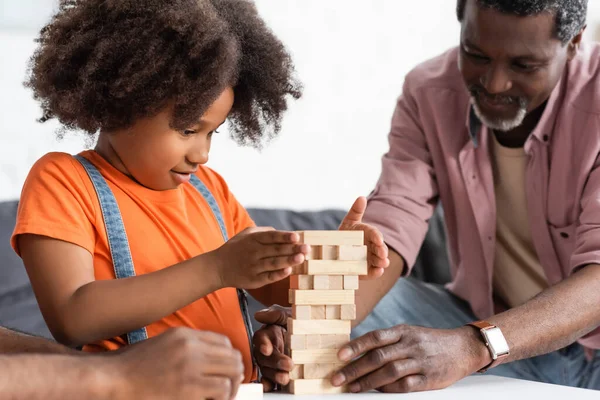Fokussiertes Afrikanisch Amerikanisches Kind Beim Holzklötzchenspiel Mit Den Eltern Hause — Stockfoto