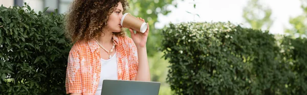 Young Woman Curly Hair Drinking Coffee Using Laptop Outdoors Banner — Stock Photo, Image
