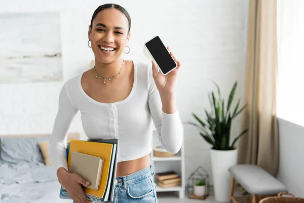 Smiling African American Student Holding Notebooks Showing Cellphone Bedroom — Stock Photo, Image