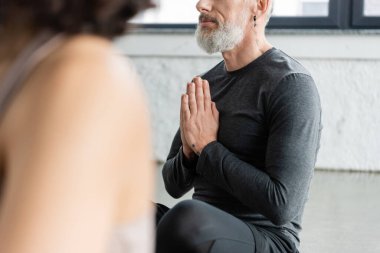 Yoga dersinde orta yaşlı bir adamın Anjali Mudra çalışması. 