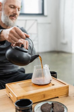 Yoga dersinde esrar içen bulanık bir olgun adam. 