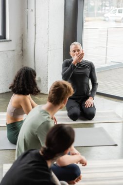 Olgun koç yoga stüdyosundaki bulanık gruba burun deliği solunumu gösteriyor. 