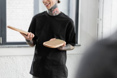 Yoga stüdyosunda elinde sadhu tahtası olan gülümseyen dövmeli bir adam görüntüsü. 