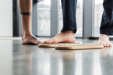 Yoga stüdyosundaki koçun yanındaki sadhu tahtasında çivi pratiği yapan adamın görüntüsü. 