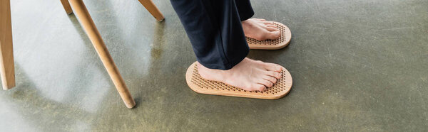 высокий угол зрения человека, ступающего босыми ногами на доске садху в студии йоги, баннер 