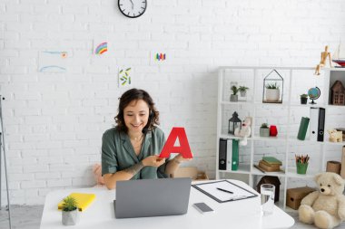 Online danışma odasında dizüstü bilgisayar dersi sırasında kulaklık takan olumlu konuşma terapisti. 
