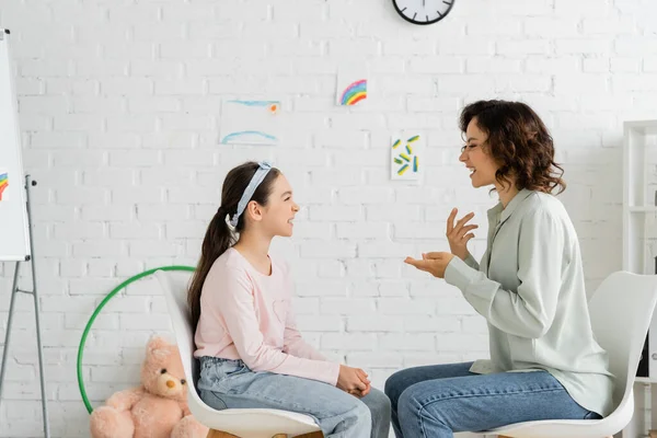 会客室内语言治疗师及儿童对话侧视图 — 图库照片