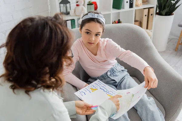 Preteen Patient Talking Blurred Psychologist Pointing Drawing Consulting Room — Stock Photo, Image