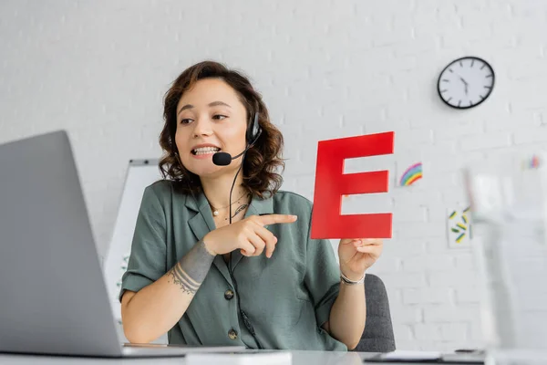 Smiling Speech Therapist Headset Pointing Letter Online Lesson Laptop Consulting — Stock Photo, Image