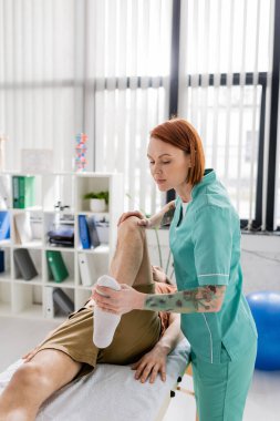 osteopath massaging injured leg of man during rehabilitation treatment in hospital clipart