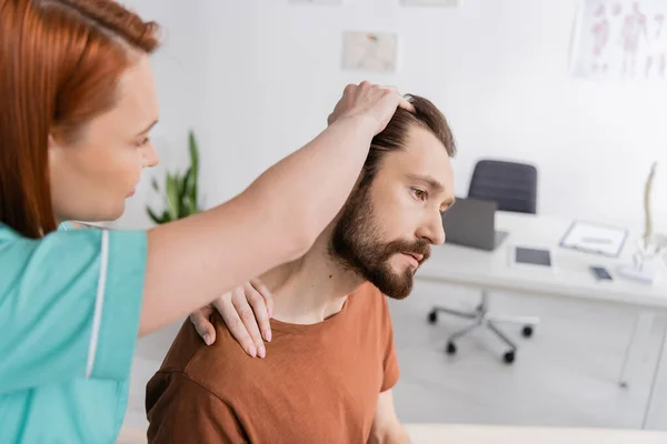 Fisioterapeuta Desfocado Examinando Homem Barbudo Com Pescoço Ferido Consultório — Fotografia de Stock