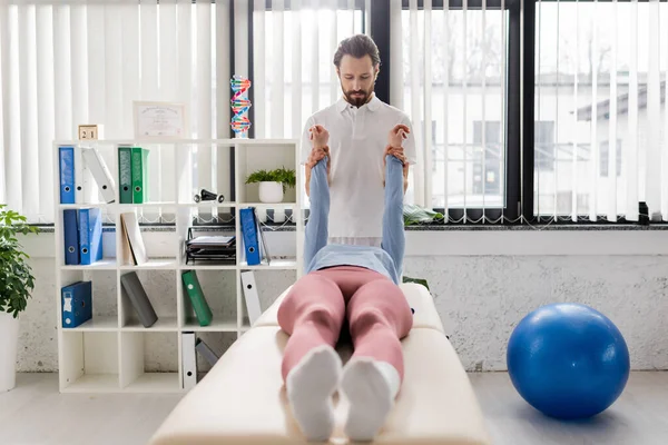 Bearded Physiotherapist Stretching Painful Arms Woman Lying Massage Table Modern — Stock Photo, Image
