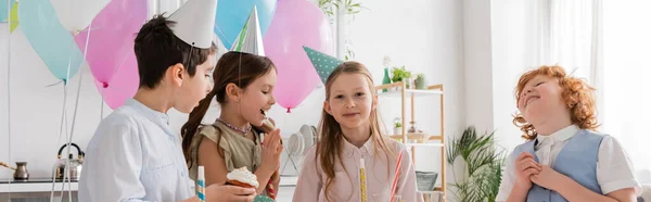 生日宴会上 十几岁的男孩在欢乐的朋友身边拿着纸杯蛋糕 一面横幅 — 图库照片