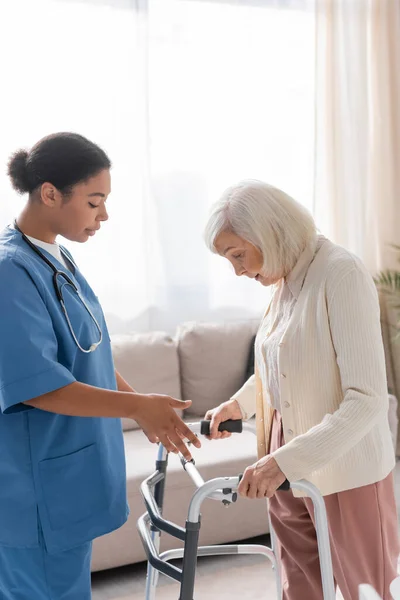 Enfermeira Multirracial Morena Uniforme Azul Olhando Para Mulher Idosa Com — Fotografia de Stock