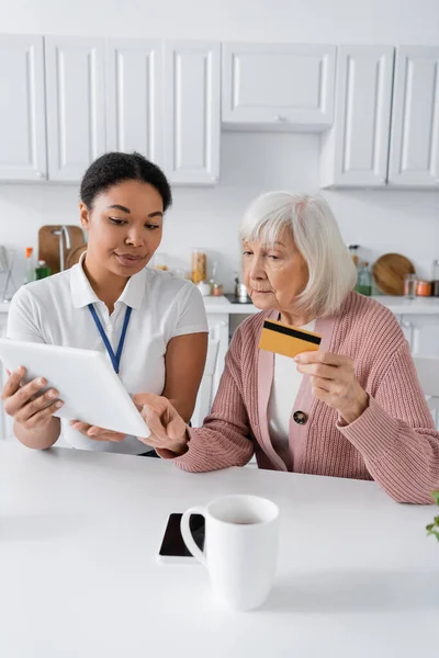 Brünette Multirassische Sozialarbeiterin Bringt Seniorin Bei Wie Man Online Einkäufe — Stockfoto