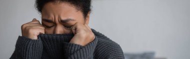 Örgü kazaklı depresyondaki kadın evde ağlıyor, afiş. 