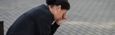 Depresyonlu genç, çok ırklı bir kadının şehir sokağına bakışı, afiş. 
