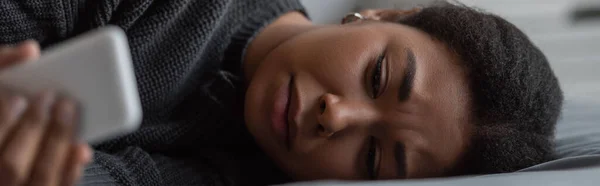 Νεαρή Πολυφυλετική Γυναίκα Κατάθλιψη Χρησιμοποιώντας Smartphone Στο Κρεβάτι Πανό — Φωτογραφία Αρχείου