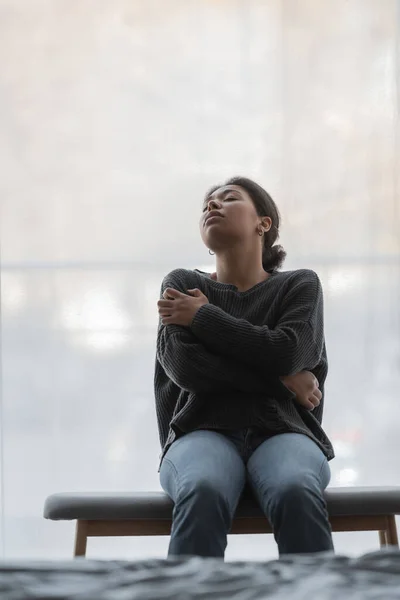 Mulher Multirracial Deprimida Sentado Otomano Perto Cortina Quarto Casa — Fotografia de Stock