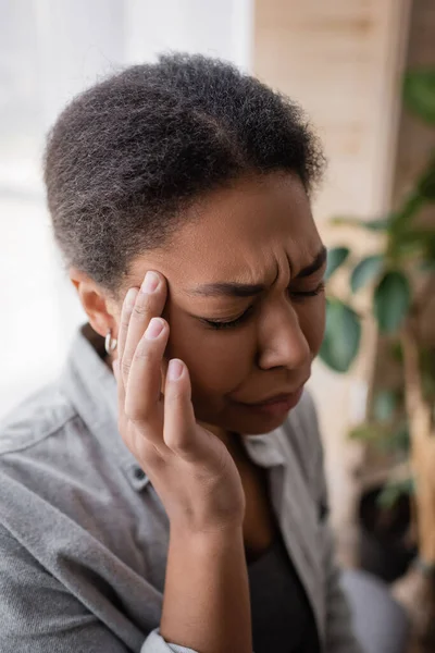 自宅で頭の痛みに苦しんでいる疲れ多人種の女性 — ストック写真