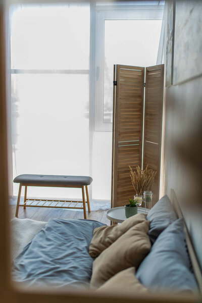 прикроватная скамейка и складной экран в спальне рядом с кроватью и тумбочкой 