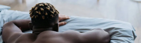 家でベッドの上でリラックスして白無垢アフリカ系アメリカ人男性のバックビュー バナー — ストック写真