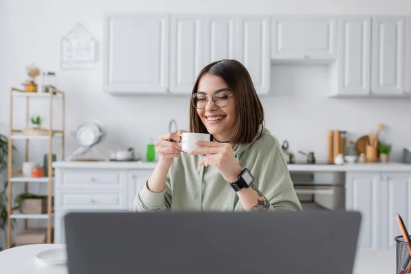 Autónomo Positivo Gafas Con Café Cerca Ordenador Portátil Borroso Casa —  Fotos de Stock