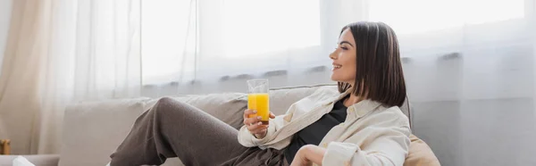 Side View Overjoyed Woman Holding Orange Juice While Sitting Couch — Stock Photo, Image