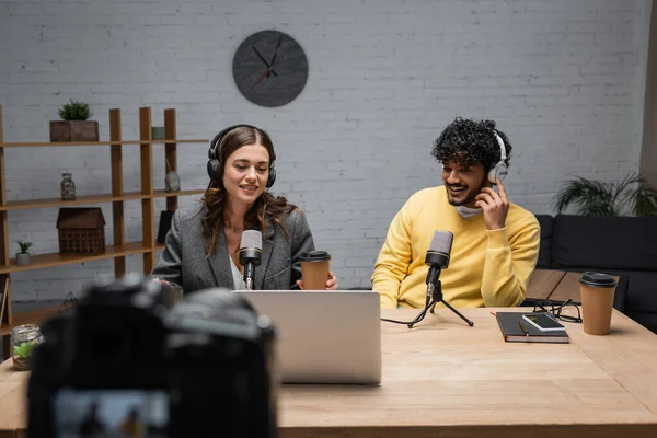 Cheerful Interracial Podcasters Headphones Working Professional Microphones Notebook Mobile Phone — Stock Photo, Image