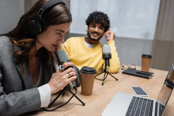 Kulaklıklı Esmer Radyo Sunucusu Laptopun Yanında Profesyonel Mikrofonla Konuşuyor Boş — Stok fotoğraf
