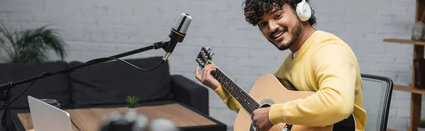 Curly Happy Indian Musician Headphones Yellow Jumper Playing Acoustic Guitar — Stock Photo, Image
