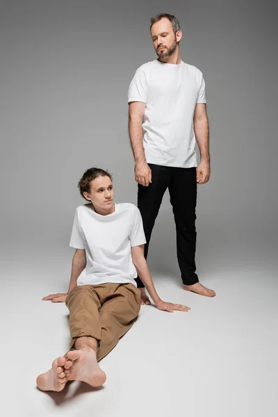 Uzun Boylu Bir Baba Gri Tişörtlü Genç Oğluna Bakıyor — Stok fotoğraf