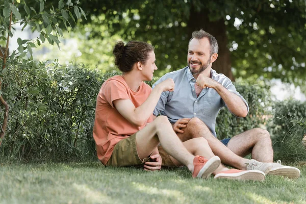 Happy Father Son Doing Fist Bump While Sitting Green Lawn — Stock Photo, Image