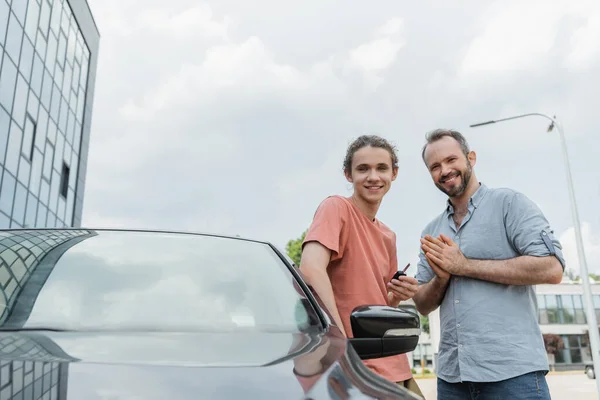 Lycklig Far Och Tonåring Son Står Tillsammans Nära Modern Bil — Stockfoto