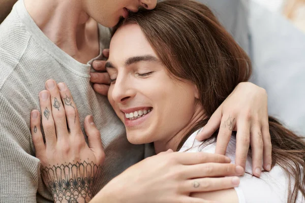 Young Gay Man Sleepwear Hugging Kissing Head Smiling Tattooed Partner — Stock Photo, Image