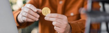 KYIV, UKRAINE - 18 Ekim 2022: Seçici altın bitcoin odaklı başarılı iş adamının elinde ofiste bulanık arka plan, kırpık manzara, afiş