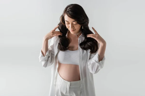 임산부 셔츠와 바지를 수염이 배경에 고립된 채바라보고 임산부 산부인과 — 스톡 사진